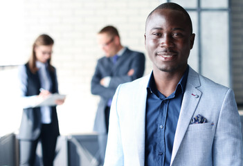 Happy black business man with people in the background