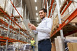 happy businessman with tablet pc at warehouse