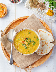 Lentil soup with bread in a ceramic white bowl Top view