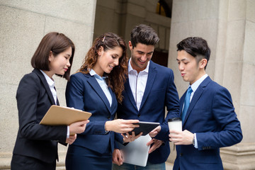 Group of business people discuss on digital tablet