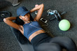 Top view of black sexy fitness instructor doing press ups at the gym and listening to music in earphones