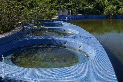 Fotografia, Obraz Abandon swimming pool and hottubs full of rain water serive as the perfect envir