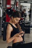 Fototapeta Na ścianę - Beautiful girl with a phone in the gym