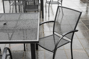 Black wrought iron patio set in the rain
