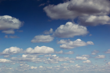 Blue sky background with soft silky clouds.