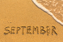 September - Written By Hand On A Golden Beach Sand.