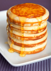 Sticker - Pile of typical American pancakes with honey on white plate