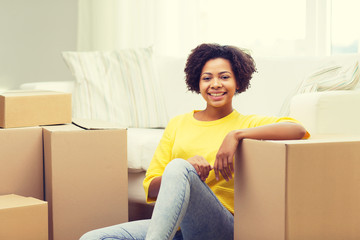 Poster - happy african woman with cardboard boxes at home