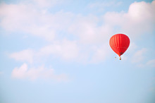 Red Hot Air Balloon In Blue Sky With White Clouds