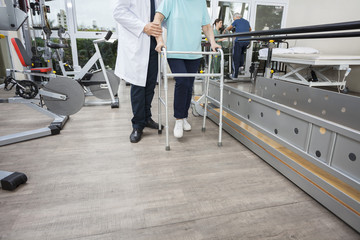 Wall Mural - Low Section Of Physiotherapist Assisting Woman With Walker