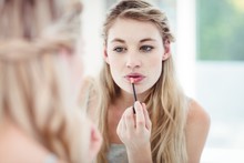Young Woman Applying Lip Gloss