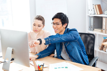 Wall Mural - Two young businesspeople working in office together