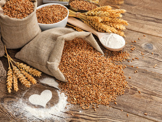 Wall Mural - wheat grain in a bag and spikes on the table