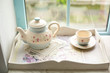 beautiful teapot and cup on a tray by the window