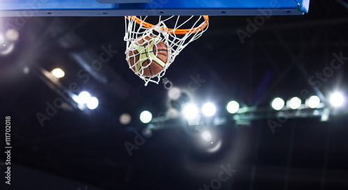 Basketball going through the hoop at a sports arena Fototapete