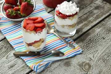 Strawberries dessert with biscuit and cream served on glasses