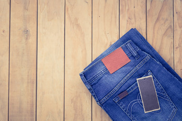 Wall Mural - Blue jeans on wooden background top view