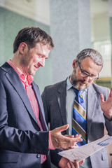 two businessmen talking in office