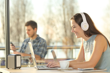 Sticker - Woman with headphones typing in a laptop