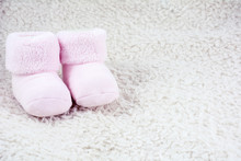Two Pink Babys Bootees On The White Fur
