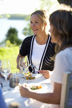 Two Women Having Lunch At A Midsummer Party, Fejan, Stockholm Archipelago, Sweden.