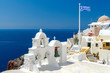 © pillerss - White bell tower and Greek flag in Oia.