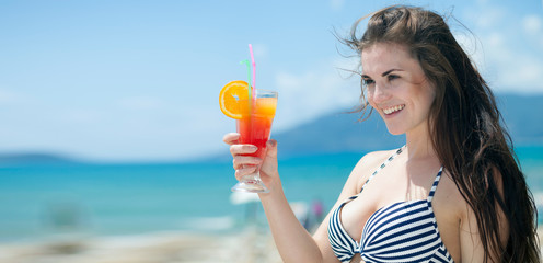 Wall Mural - Woman with cocktail on the beach during tropical vacation