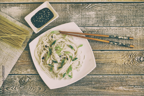Fényképezés Bowl of rice noodles on wooden table. Vintage and retro toning
