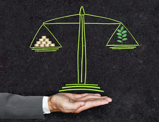 Measuring tree and golden coins on a balance scale / Business ethics