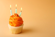 Birthday Cupcake With Candle On Color Background