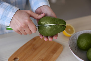 Sticker - Woman cutting fresh avocado in kitchen