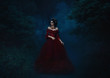 dark evil queen sneaks through the dark forest at night,   Princess in red dress , vampire , hip toning , creative color,dark boho