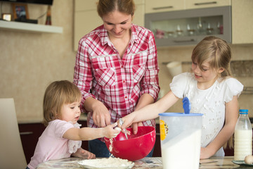 baby girls, Mom. child 2 years of a child 7 years old and their mother preparing breakfast in the kitchen.