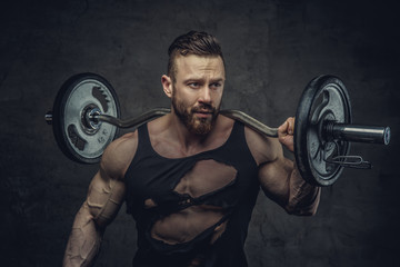 Wall Mural - Portrait of bearded bodybuilder with barbell on his shoulder.