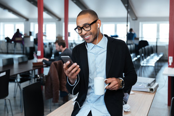smiling businessman texting message on the smartphone