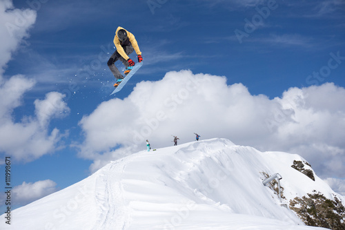 Cuadros en Lienzo Corredor de snowboard que salta sobre las montañas