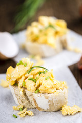 Wall Mural - Fresh baked Bun with Scrambled Eggs on wooden background