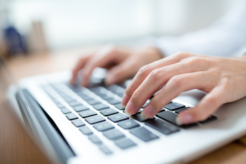 Female hands typing on laptop