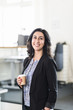© Johnér - Young businesswoman in office with coffee