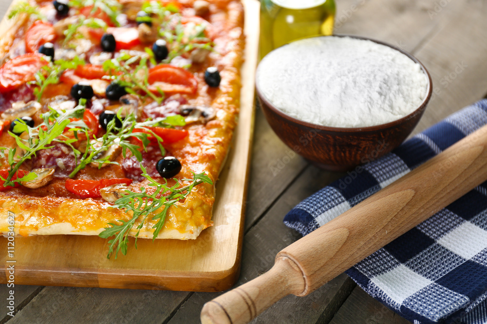 Rectangle delicious pizza and vegetables on the table, close-up