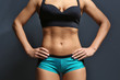 © Africa Studio - Female fitness model on dark grey background
