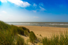 People Walking In Distance At The Belgian North Sea Coast Near De Haan, Belgium