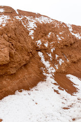 snow on red clay in nature