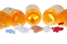Five Prescription Bottles Lined Up On Their Sides Spilling Medication Pills Out Onto A White Table Surface Isolated On A White Background. Depicting Multiple Medications, Overwhelming To Keep Track Of