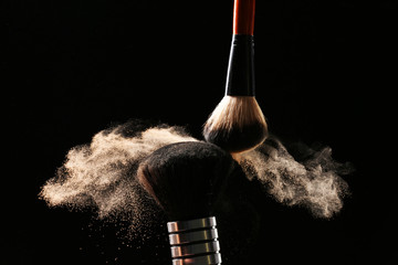 Poster - Two make up brushes with powder on black background