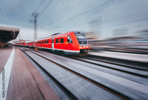 Cuadros en Lienzo Estación de ferrocarril con el tren de pasajeros rojo de alta velocidad moderno en la puesta del sol en Nuremberg, Alemania