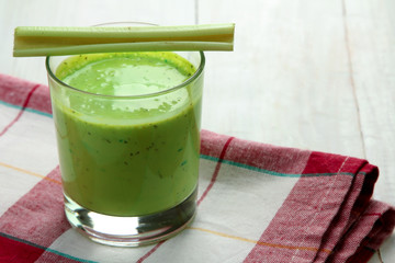 Wall Mural - Fresh green celery juice in glass on white wooden background