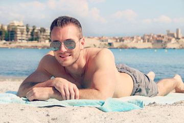 Wall Mural - Handsome male lying on the sand