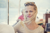 Fototapeta  - Piękna kobieta z rozwianymi wiatrem blond włosami podróżująca statkiem