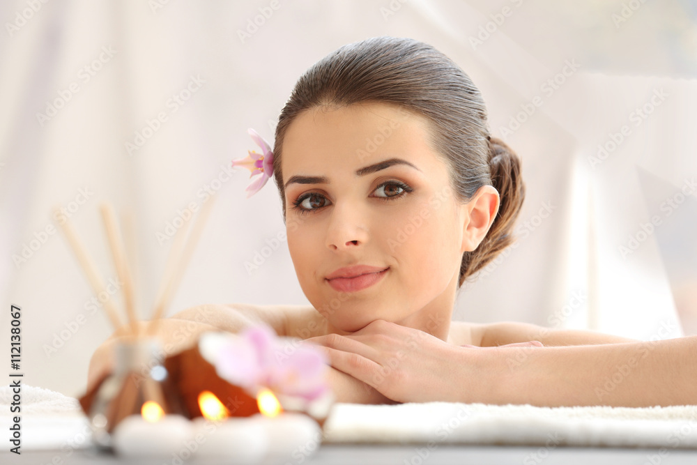 Young woman with flower relaxing in spa center